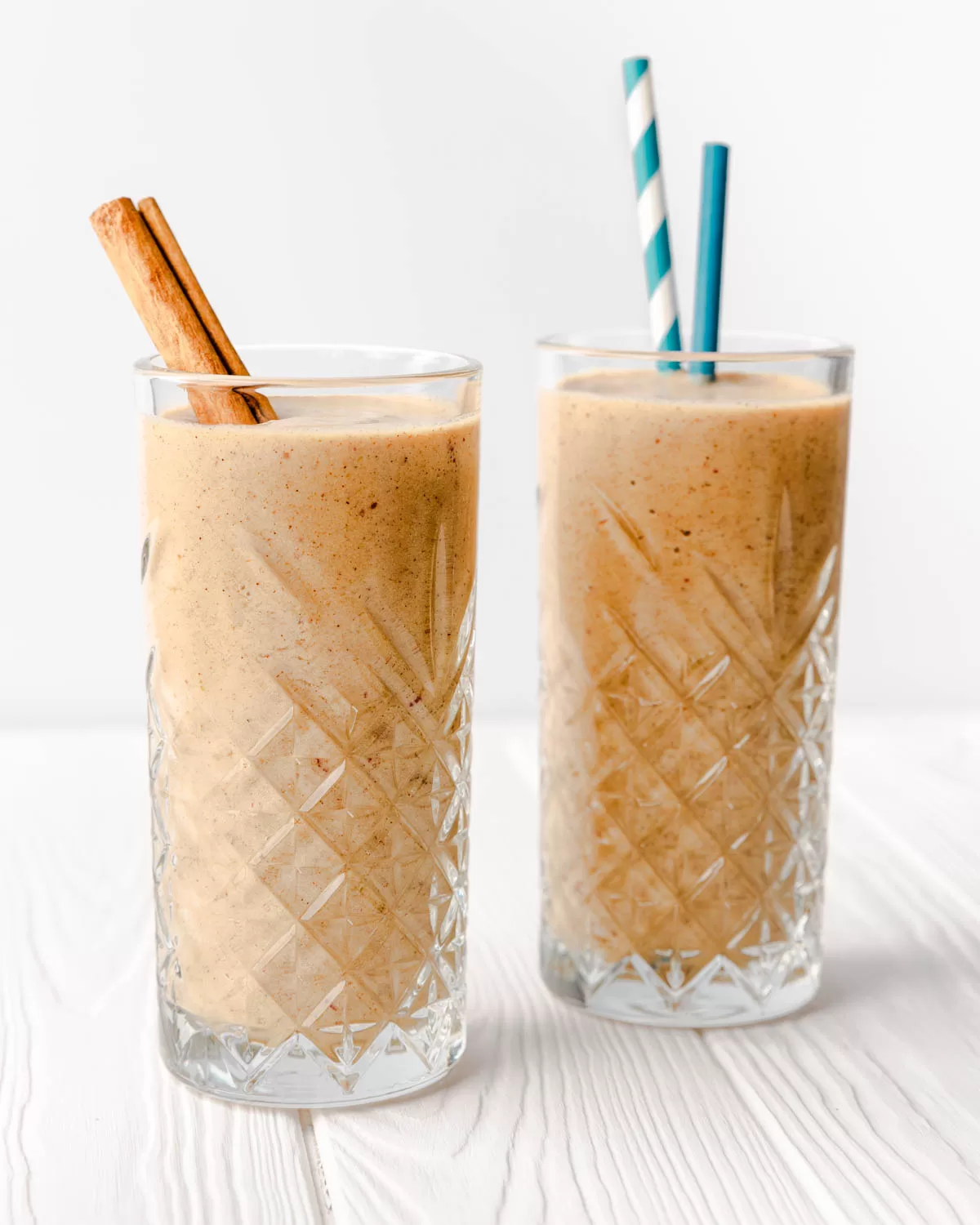 two glasses of apple smoothie with blue straws