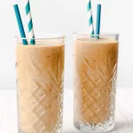two glasses of apple smoothie with blue straws