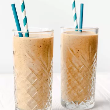 two glasses of apple smoothie with blue straws